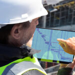 Two Syklo employees are looking at data on a tablet.