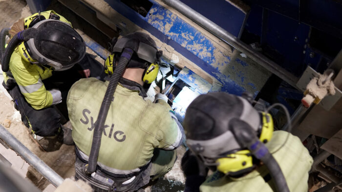 Syklon käyttöhenkilöt lajittelulinjaston kimpussa