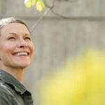 Anne Raudaskoski is looking at the sky with a big smile on her face.