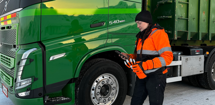 Pipopäinen nainen kännykkä kädessään selaa mobiilisovellusta.