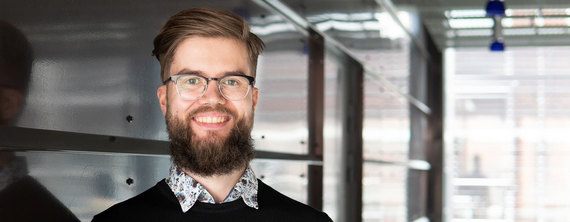 Lähikuva Eero Martikaisesta valoisassa aulatilassa.