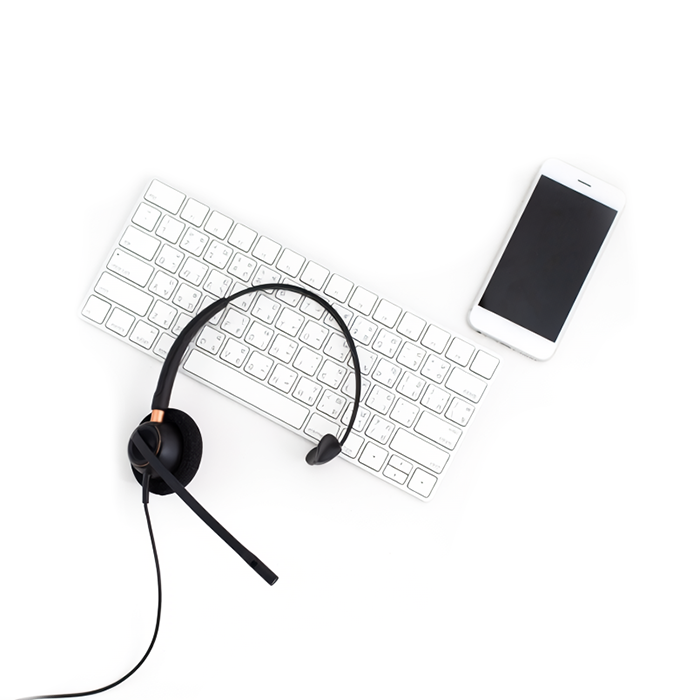 Kuulokkeet, näppäimistö ja kännykkä ovat valkoisella tasolla.